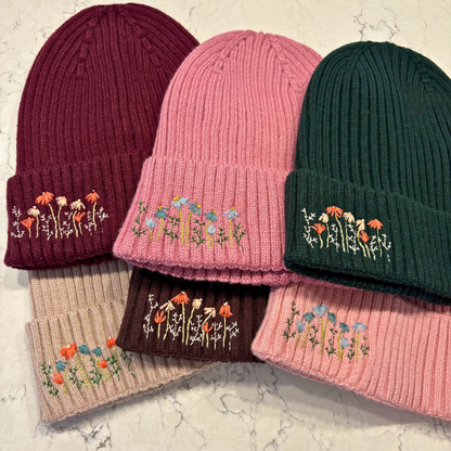 6 beanies with dainty embroidered floral design in bottom left corner.