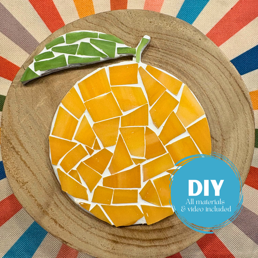 Mosaic orange on a wooden board with a colorful striped background