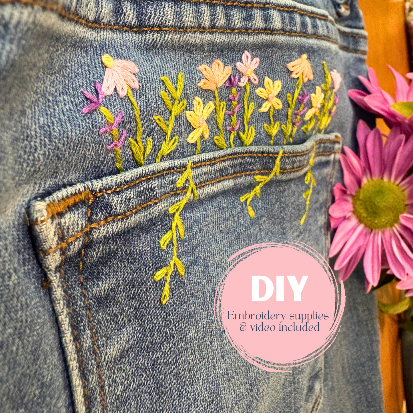 Embroidered floral design on denim fabric with a pink flower in the foreground and 'DIY' label.