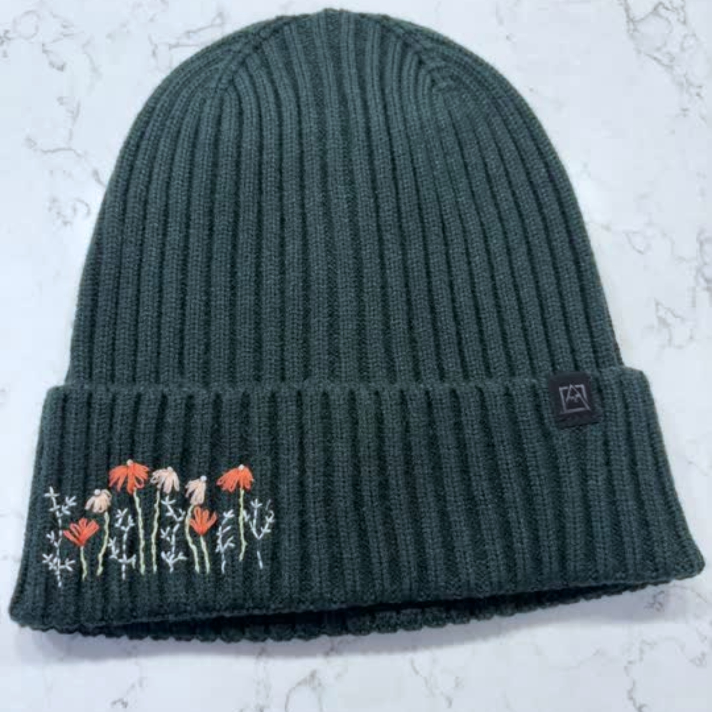 Gray-Green beanie with dainty embroidered floral design in bottom left corner.